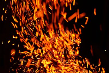 Yangının neden olduğu fırtına doku. Bokeh ışık siyah arka plan üzerine, havada uçan ateş çekim kıvılcım