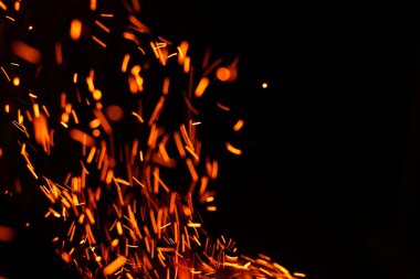 Yangının neden olduğu fırtına doku. Bokeh ışık siyah arka plan üzerine, havada uçan ateş çekim kıvılcım