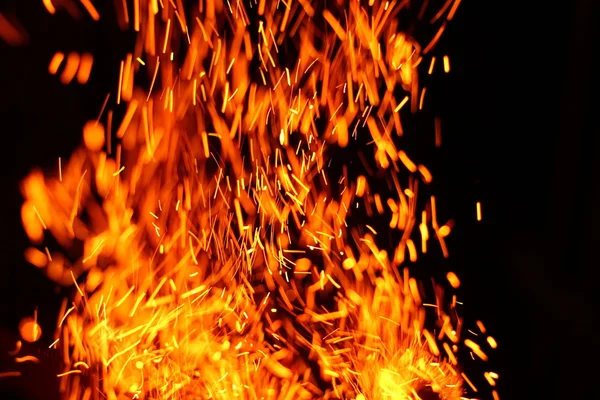 Firestorm texture. Bokeh lights on black background, shot of flying fire sparks in the air