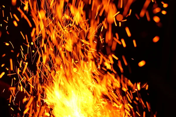 Yangının neden olduğu fırtına doku. Bokeh ışık siyah arka plan üzerine, havada uçan ateş çekim kıvılcım