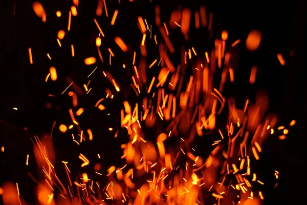 Firestorm texture. Bokeh lights on black background, shot of flying fire sparks in the air — Stock Photo, Image