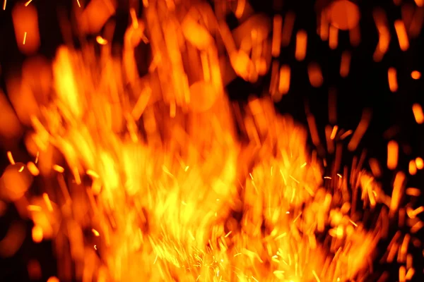 Yangının neden olduğu fırtına doku. Bokeh ışık siyah arka plan üzerine, havada uçan ateş çekim kıvılcım