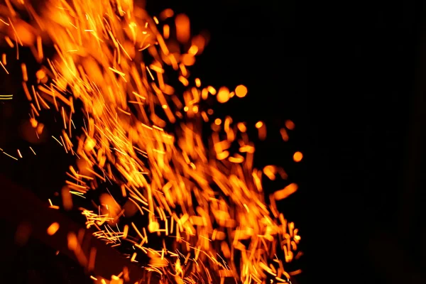 Firestorm texture. Bokeh lights on black background, shot of flying fire sparks in the air — Stock Photo, Image