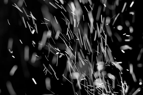 暴风雪的纹理。在黑色背景上的散景灯拍摄的飞片雪花在空中 — 图库照片