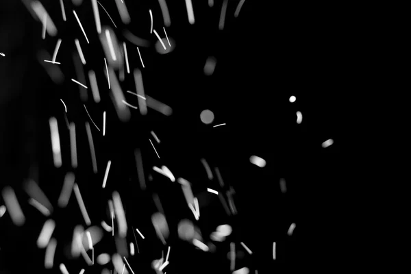 Snowstorm texture. Bokeh lights on black background, shot of flying snowflakes in the air — Stock Photo, Image