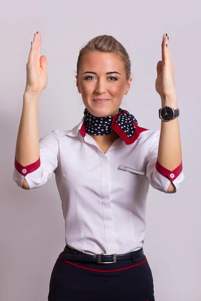 Encantadora aeromoça vestida de uniforme azul em fundo cinza — Fotografia de Stock