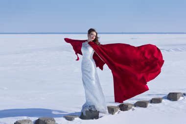 Kadın beyaz elbise kumaş uçan kırmızı ile sallayarak