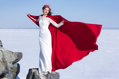 Kadın beyaz elbise kumaş uçan kırmızı ile sallayarak