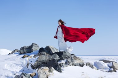 Kadın beyaz elbise kumaş uçan kırmızı ile sallayarak