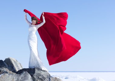 Kadın beyaz elbise kumaş uçan kırmızı ile sallayarak