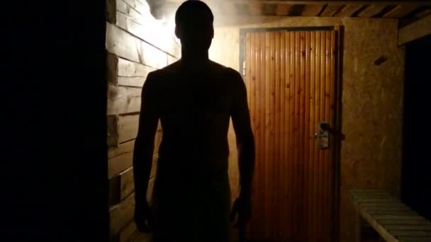 Az ember sziluettje egy szauna tornácon fürdő után — Stock videók