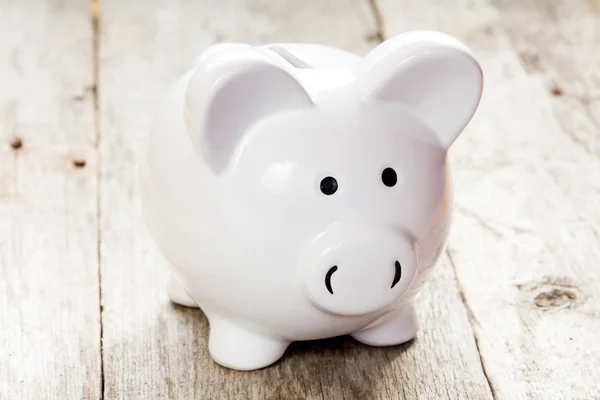 Witte piggy bank op houten vloer — Stockfoto