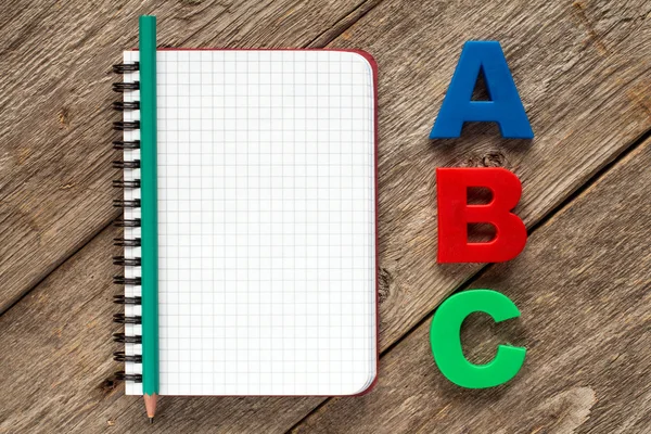 Notizbuch mit Bleistift und Abc-Buchstaben — Stockfoto