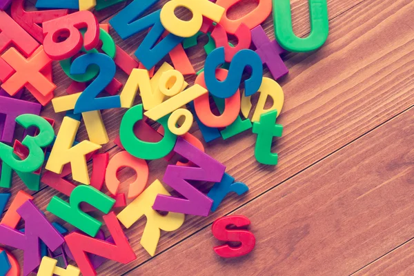 Colorful toy magnets on wooden background. — Stock Photo, Image