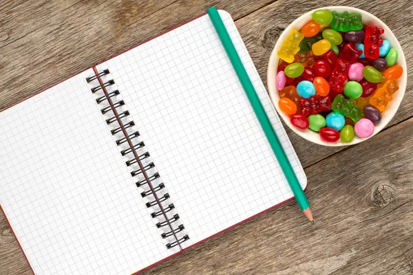 Cuaderno espiral y recipiente con caramelos — Foto de Stock