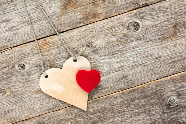 Láska srdce visí na dřevěné pozadí. — Stock fotografie