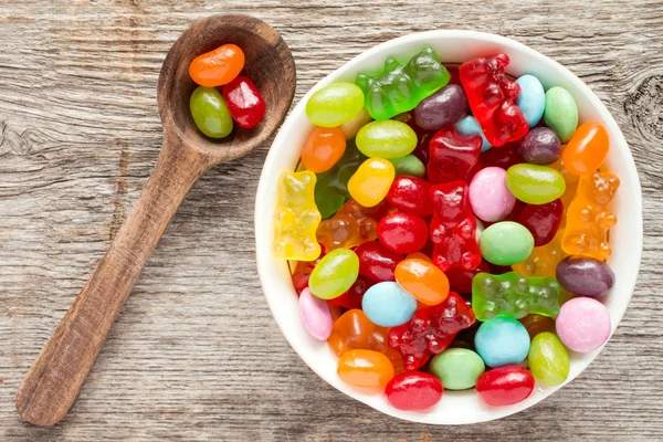 Spoon and bowl  of various candies — Stock Photo, Image