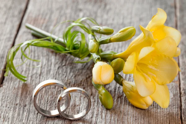 Anéis de casamento com flor frésia — Fotografia de Stock