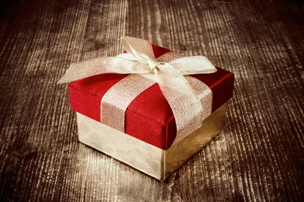 Geschenk-Box auf dem dunklen Holzboden. — Stockfoto