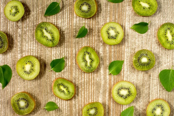 Sliced kiwi fruit and green leaves — Stock Photo, Image