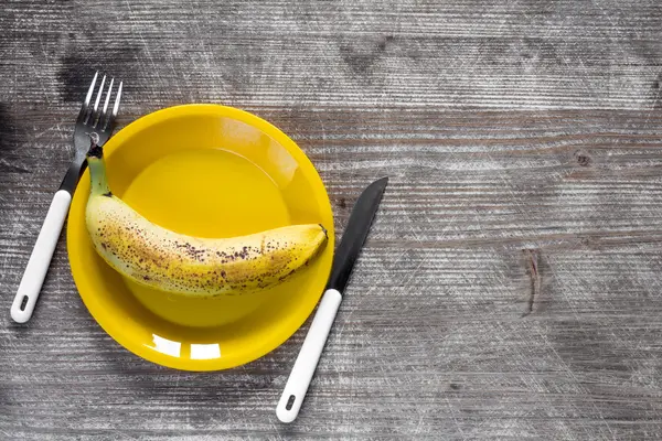 Plaque de fourchette, couteau et jaune à la banane — Photo