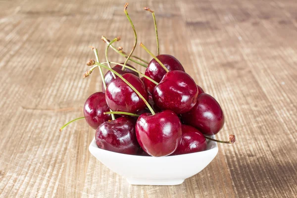 Cerejas em tigela branca — Fotografia de Stock