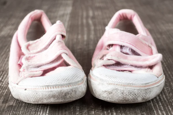 Vecchie scarpe da tennis rosa su superficie di legno — Foto Stock
