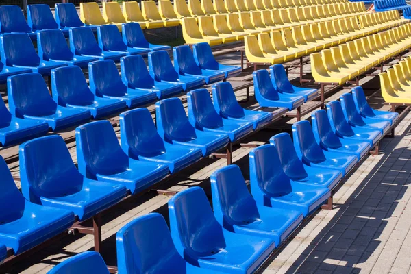 Chaises bleues et jaunes au stade — Photo