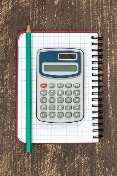Digital calculator and spiral notebook with pencil — Stock Photo, Image