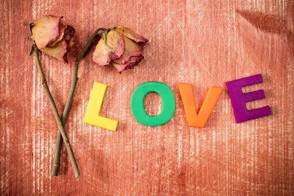 Dos viejas rosas con la palabra amor — Foto de Stock