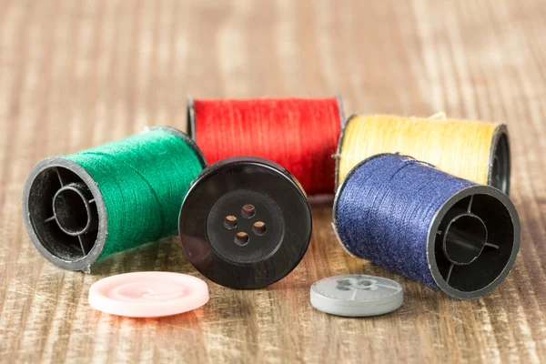 Spoelen van gekleurde wol en knoppen — Stockfoto