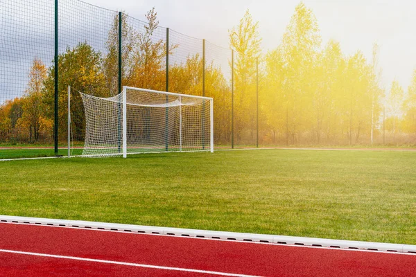 Athletics stadium. Outdoor athletics treadmill running track lines with behind football gate.