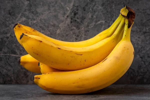 灰色の石の背景に黄色のバナナを熟す バナナの果実はマグネシウム ビタミンB6 ビタミンCの大きな供給源です — ストック写真