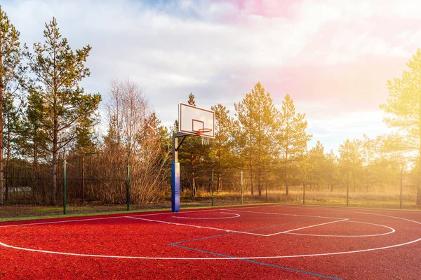 An empty basketball court found in the outdoors during autumn season