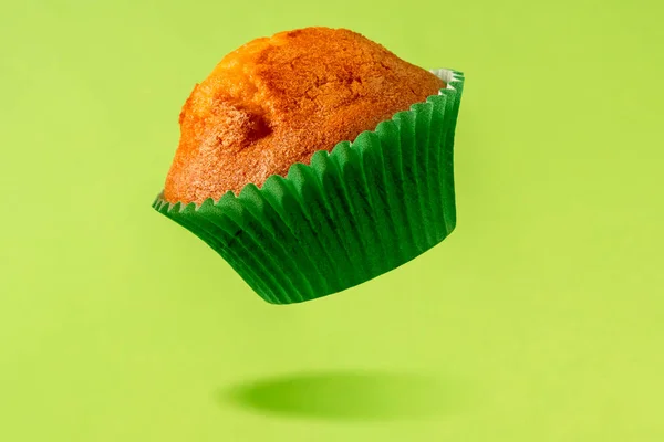 Muffin Baking Paper Cup Levitating Green Background — Stock Photo, Image