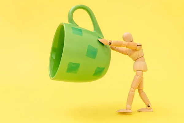 Wooden Man Holding Green Cup Floating Yellow Background — Stock Photo, Image