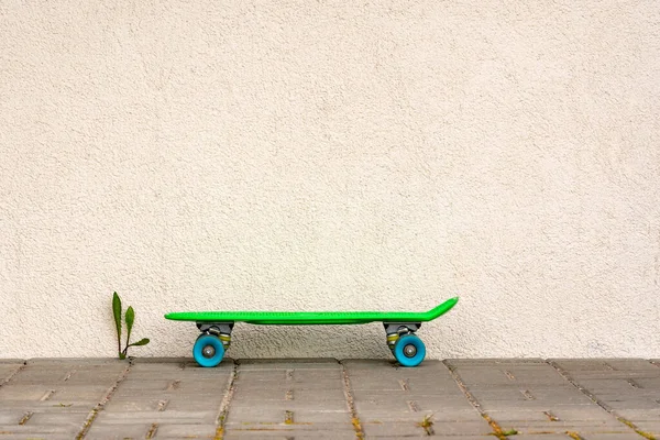 Skate Plástico Verde Pavimento Contra Parede Branca Espaço Cópia — Fotografia de Stock