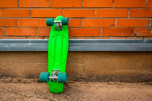 Joven Culture Green Monopatín Apoyado Contra Pared Ladrillo —  Fotos de Stock