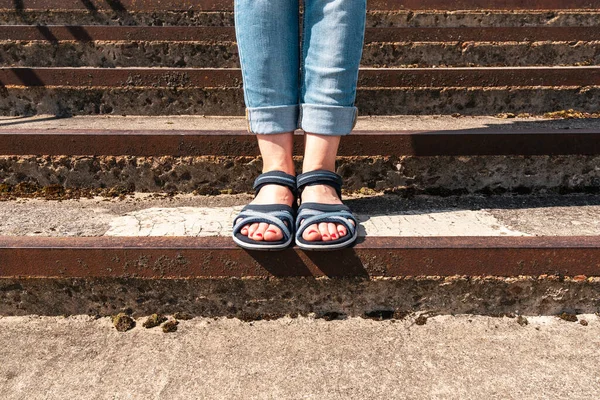 夏のサンダルの女性の足は 具体的な階段の上に立つ 街の通りで女の子快適な夏の靴 — ストック写真