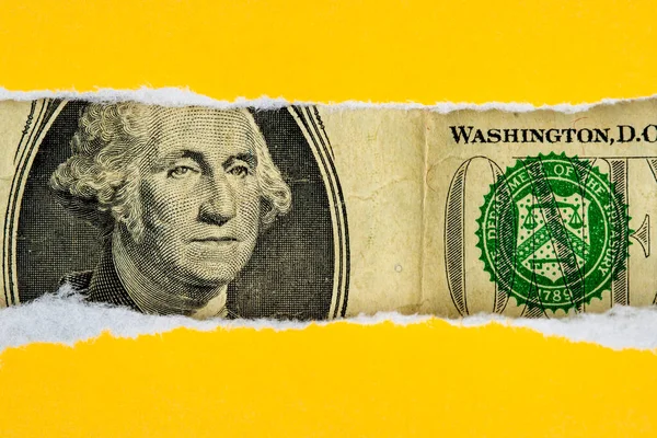 破れた黄色の紙を通した米国通貨マクロの覗き見 — ストック写真