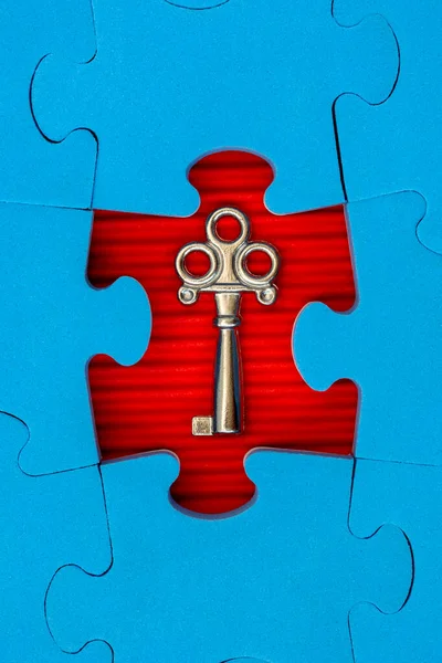 Find key to success, business opportunity or solution. Jigsaw puzzle with small metal key.