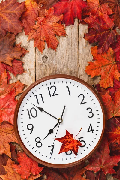 秋天的树叶和墙上的时钟在木材的背景上 秋季时间 — 图库照片