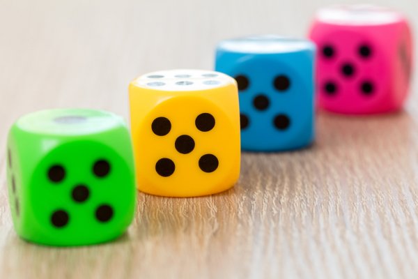 Four colorful dice on the wooden surface — Stock Photo, Image