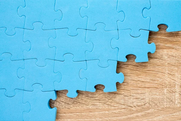 Jigsaw puzzle su fondo di legno — Foto Stock