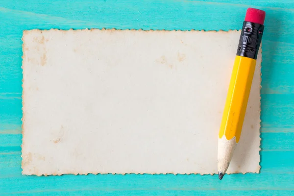 Pencil with old paper on the blue surface — Stock Photo, Image