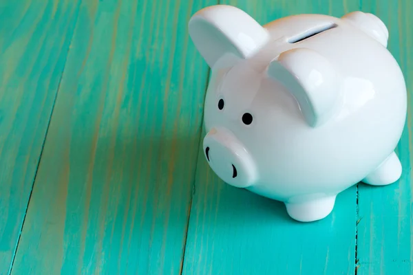 Piggy bank on the blue wooden surface — Stock Photo, Image