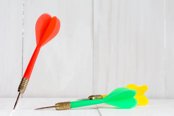 Darts on a white wooden background — Stock Photo, Image