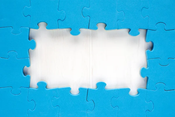 Blue jigsaw puzzle pieces arranged as a border — Stock Photo, Image