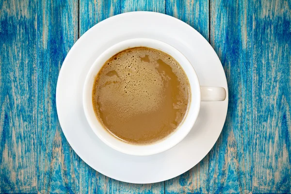 Cup of coffee on blue wooden surface — Stock Photo, Image