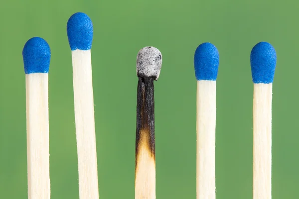 Row of match sticks on  green background — Stock Photo, Image